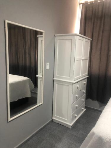 1 dormitorio con tocador blanco y espejo en PRAIA DO FORTE, en Cabo Frío