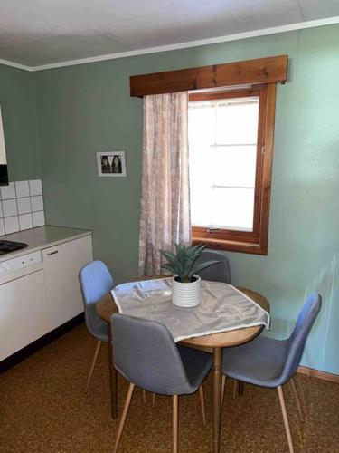 a kitchen with a table with chairs and a window at Fin, enkel leilighet med nydelig strand i nærheten in Åmdals Verk