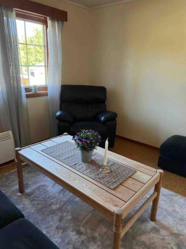 sala de estar con mesa de centro y silla en Fin, enkel leilighet med nydelig strand i nærheten, en Åmdals Verk