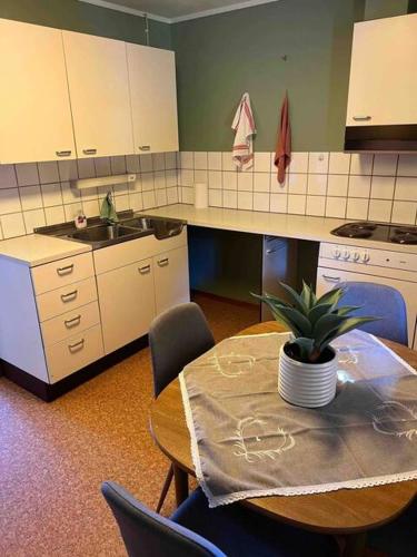 una cocina con una mesa con una maceta. en Fin, enkel leilighet med nydelig strand i nærheten, en Åmdals Verk
