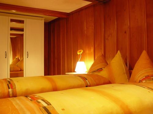 a bedroom with two beds and a table with a lamp at Apartment Lindi in Lütschental