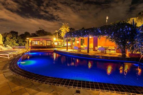 a swimming pool in front of a house at night at Villas do Pratagy Jambo I com Jacuzzy in Maceió