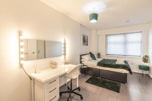 a bedroom with a bed and a desk and a mirror at City centre apartment in Birmingham