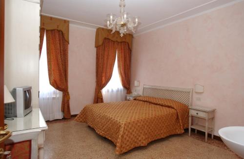 a bedroom with a bed and a chandelier at Casa Mimma in Venice