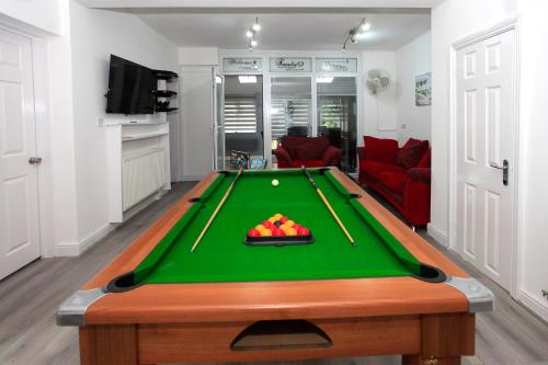 a living room with a pool table in front of a room at Luxury Hot Tub - Entertainment Room - Near Central Park! in Peterborough