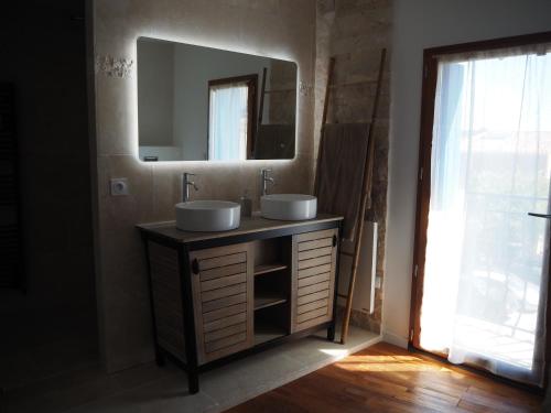 een badkamer met 2 wastafels en een spiegel bij La Trémière, maison de village, sauna, vue garrigue in Bouzigues