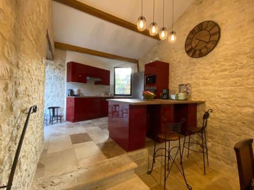 a kitchen with red cabinets and a counter in a room at Maison de village, charme et confort in Mauroux