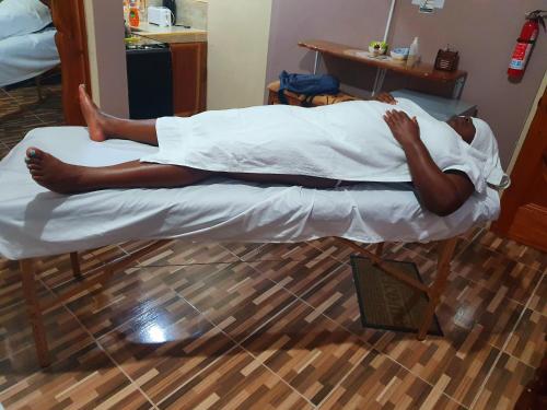 a man laying on a bed in a room at Mesmerize Guest House in Port Antonio