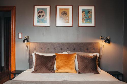 um quarto com uma cama com três fotografias na parede em William Arnott Boutique Accommodation em Morpeth