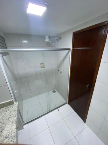 um chuveiro com uma porta de vidro na casa de banho em Quarto139 Portobello Park em Porto Seguro