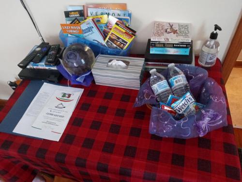 a table topped with a blanket with books and other items at Studio Apartment in Lake George Area. Near Vermont in Granville