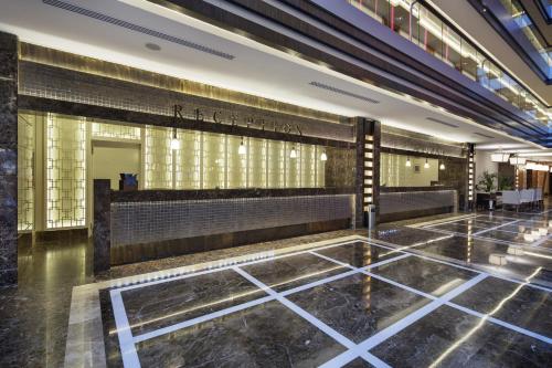 a lobby of a building with benches and windows at Liberty Hotels Lara in Lara