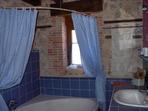 a bathroom with a tub and a sink and a window at Casa Rural Pincherres in Mata de Quintanar