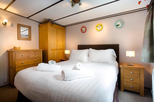 ein Schlafzimmer mit einem großen weißen Bett mit Handtüchern darauf in der Unterkunft Low Tarn Lodge in Elterwater