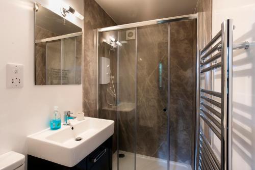 a bathroom with a sink and a shower at Low Tarn Lodge in Elterwater