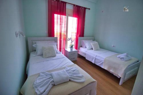 1 dormitorio con 2 camas y ventana en DAI Apartments, en Gjirokastra