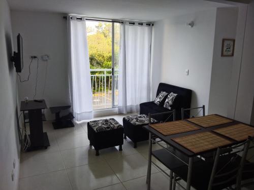 een woonkamer met een bank en een tafel bij Apartamento Amoblado Conjunto Terraverde in Ibagué