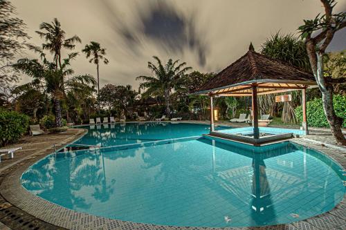 a large swimming pool with a gazebo at Panorama Cottages I in Legian
