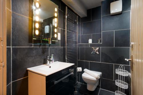 a bathroom with a sink and a toilet and a mirror at Jontys Cottage in Ambleside