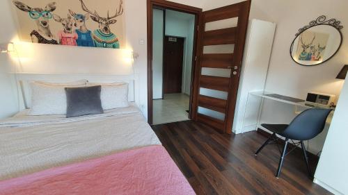 een slaapkamer met een bed, een stoel en een spiegel bij Apartament Przy Starówce - Stella in Bolesławiec