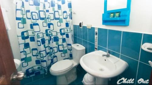ein Badezimmer mit einer weißen Toilette und einem Waschbecken in der Unterkunft CHILL OUT in Huanchaco