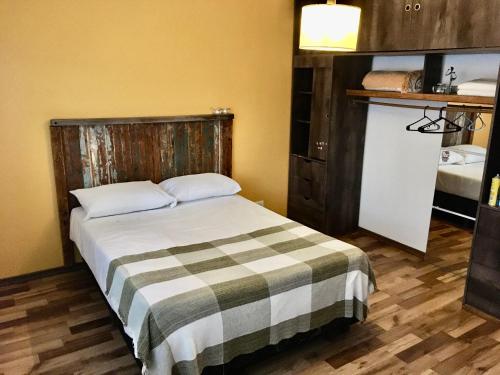 1 dormitorio con 1 cama con manta a cuadros en La Ventolina en Puerto Pirámides