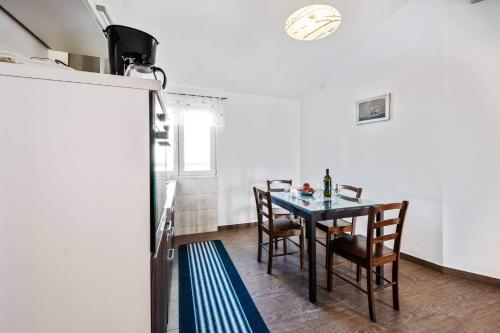 a dining room with a table and chairs and a refrigerator at Seaside family friendly house with a swimming pool Razanj, Rogoznica - 19735 in Rogoznica