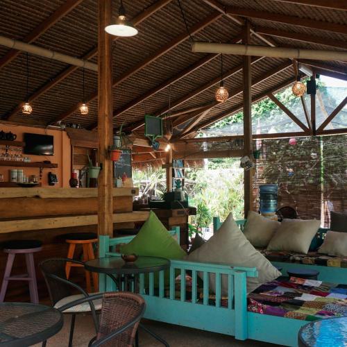 a living room with a couch and a table and chairs at SAME SAME Bungalows by The Spot in Kuta Lombok