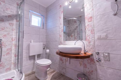 a bathroom with a sink and a toilet and a shower at Apartments for families with children Banjol, Rab - 19804 in Rab