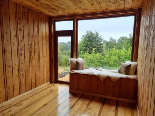 a room with a window and a window seat with a view at PARCELA DE AGRADO CON PISCINA LAGO RANCO todas las instalaciones con uso exclusivo capacidad 20 personas in Lago Ranco