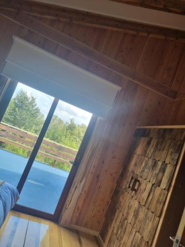 a large window in a room with a wooden floor at PARCELA DE AGRADO CON PISCINA LAGO RANCO todas las instalaciones con uso exclusivo capacidad 20 personas in Lago Ranco