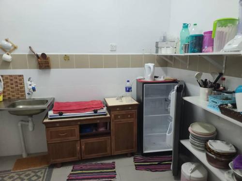 uma pequena cozinha com um lavatório e um frigorífico em Sobey Laris Homestay KokLanas em Ketereh
