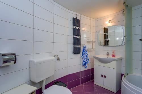 a bathroom with a toilet and a sink at Apartments by the sea Veli Losinj, Losinj - 19782 in Veli Lošinj