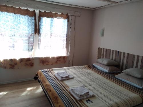 Уютный ночлег Иссыкские курганы في Rakhat: غرفة نوم بسرير ونافذة