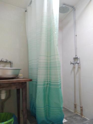 a shower curtain in a bathroom with a sink at Уютный ночлег Иссыкские курганы in Rakhat