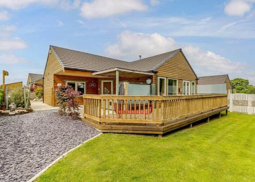 a house with a large deck in the yard at Durham Coastal Lodges in Haswell