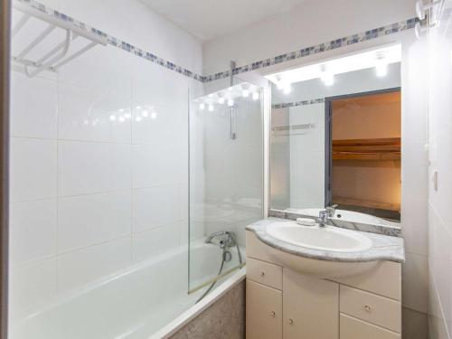 une salle de bain avec un lavabo, une baignoire et un miroir dans l'établissement Studio cabine 4 pers avec terrasse, piscine couverte et salle de fitness, proche pistes et remontées - FR-1-404-339, à La Mongie
