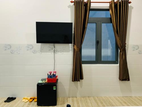 Cette chambre dispose d'une télévision et d'une fenêtre. dans l'établissement Hải An Homestay - Garden by the Beach, à Phan Rang