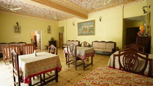 un comedor con mesas y sillas y un sofá en Anuraag Villa, en Jaipur