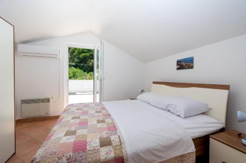 a white bedroom with a bed and a window at Apartments by the sea Tkon, Pasman - 19913 in Tkon