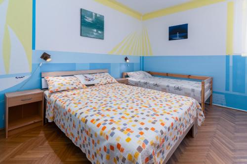 a bedroom with two beds and blue walls at Apartments by the sea Punat, Krk - 19831 in Punat
