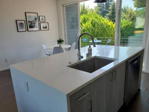 a kitchen with a sink and a large window at Modern Townhome Rooftop Deck, Office and King Bed in Seattle