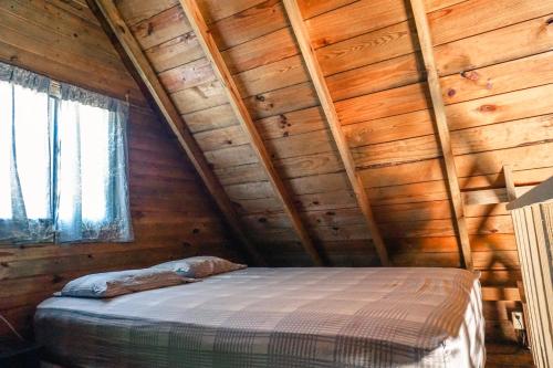 ein Schlafzimmer mit einem Bett in einer Holzhütte in der Unterkunft Rancho Estero in Santa Catalina