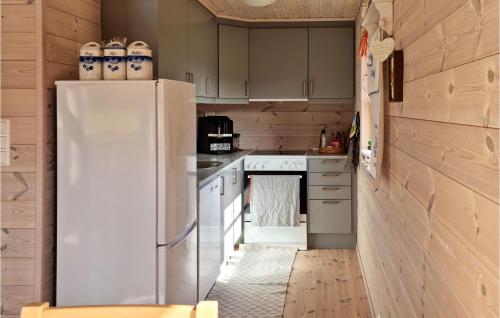 a kitchen with a white refrigerator and white cabinets at 3 Bedroom Amazing Home In Vikes in Vikeså