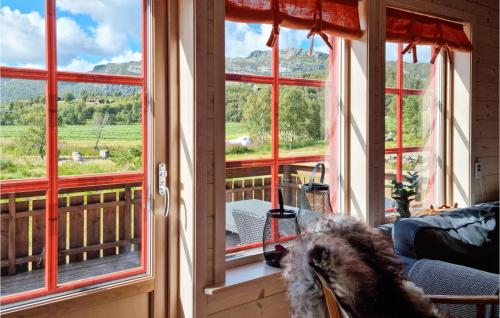 a dog sitting on a couch in front of a window at 3 Bedroom Amazing Home In Vikeså in Vikeså
