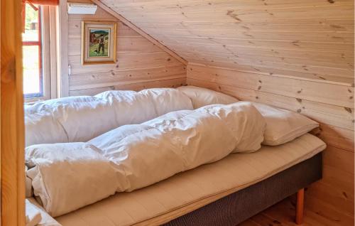 a large couch in a room with a wooden wall at 3 Bedroom Amazing Home In Vikes in Vikeså