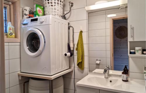 a bathroom with a washing machine next to a sink at 3 Bedroom Amazing Home In Vikeså in Vikeså