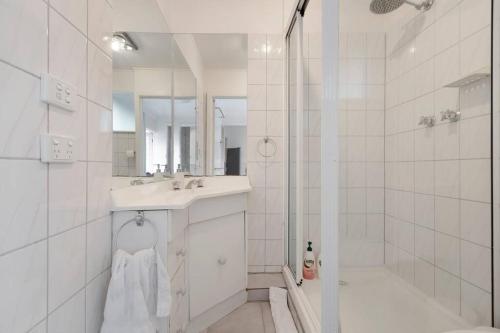 La salle de bains blanche est pourvue d'un lavabo et d'une douche. dans l'établissement Comfortable Richmond home - Melbourne’s best location, à Melbourne