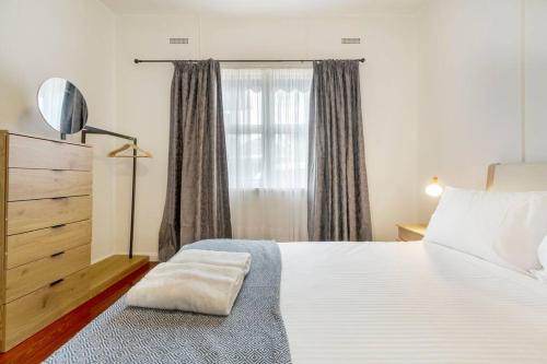 a bedroom with a large white bed and a window at Comfortable Richmond home - Melbourne’s best location in Melbourne