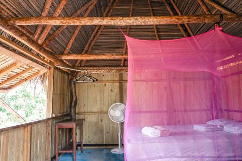 Cama en habitación con mosquitera rosa en Rancho Estero en Santa Catalina